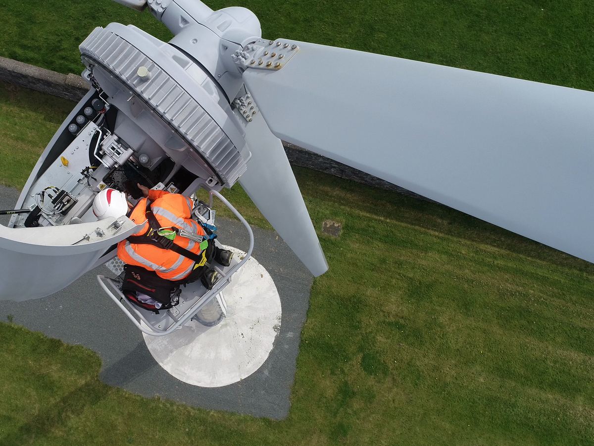 Seen from above: a technician working inside the open nacelle at the top of the tower